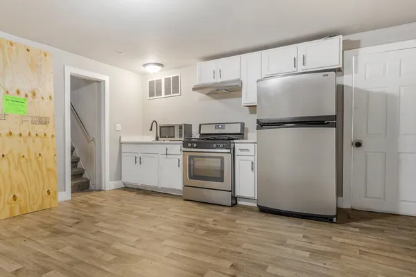 a kitchen with stainless steel appliances a refrigerator stove and white cabinets