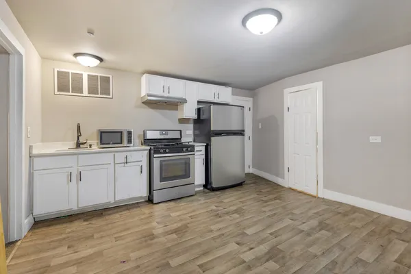 a kitchen with refrigerator cabinets and wooden floor