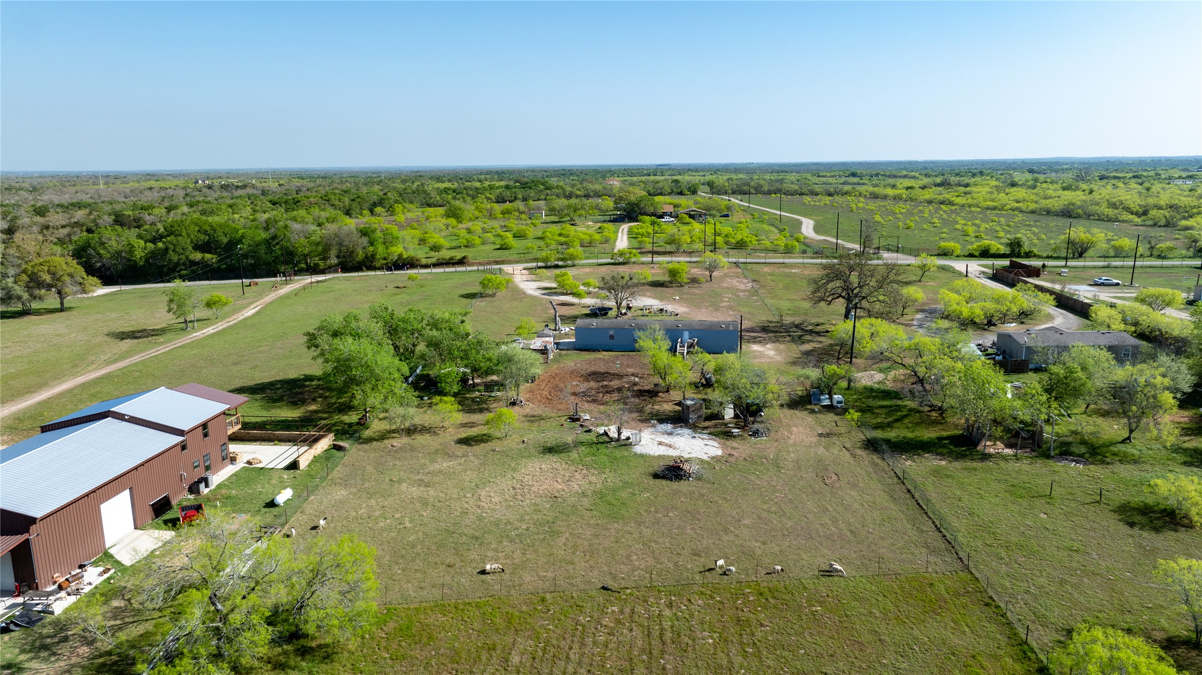 6575 Taylorsville Road Dale, TX 78616 - Photo 8 of 15 An expansive rural landscape awaits, featuring a mix of cleared pasture, mature trees, and natural wilderness.