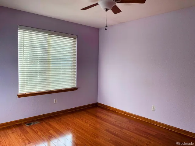 an empty room with closet and windows