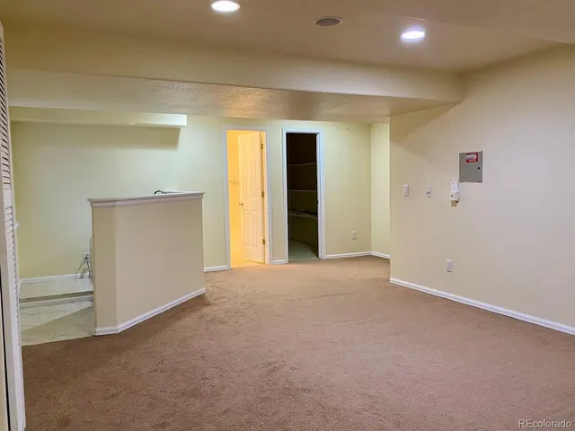 a view of an empty room with closet and a window