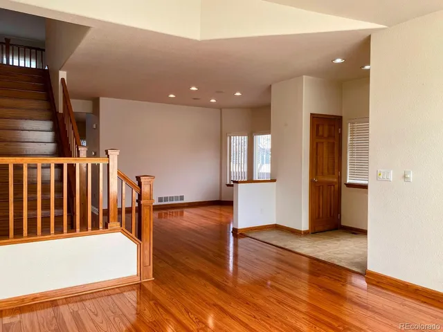 a view of hallway with stairs and wooden floor