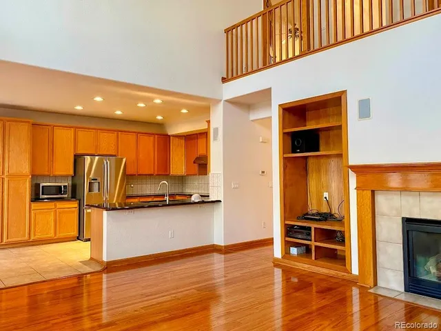 a view of a livingroom with wooden floor and a fireplace