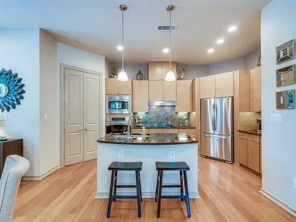 a kitchen with refrigerator a sink and chairs
