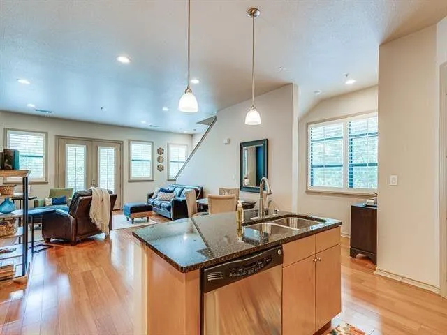 a kitchen with granite countertop a stove and a living room view