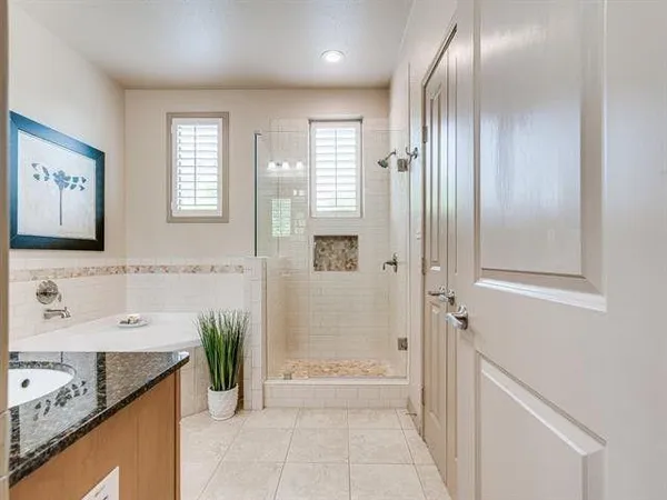 a bathroom with a granite countertop sink a mirror and a bathtub