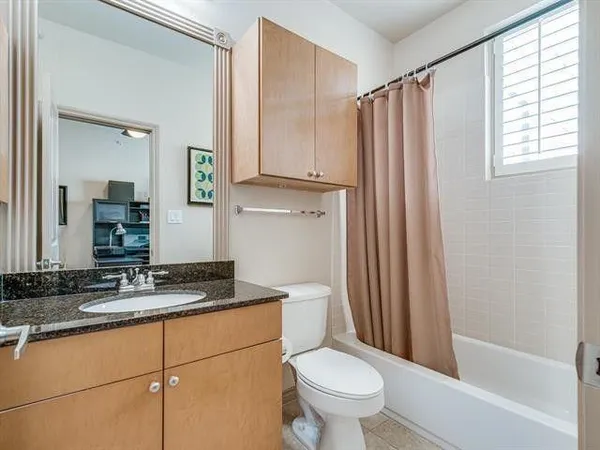 a bathroom with a granite countertop sink toilet and shower
