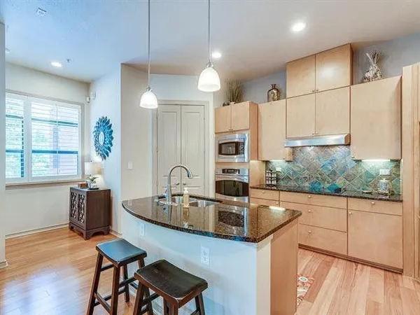 a kitchen with stainless steel appliances kitchen island granite countertop a stove a refrigerator and a microwave