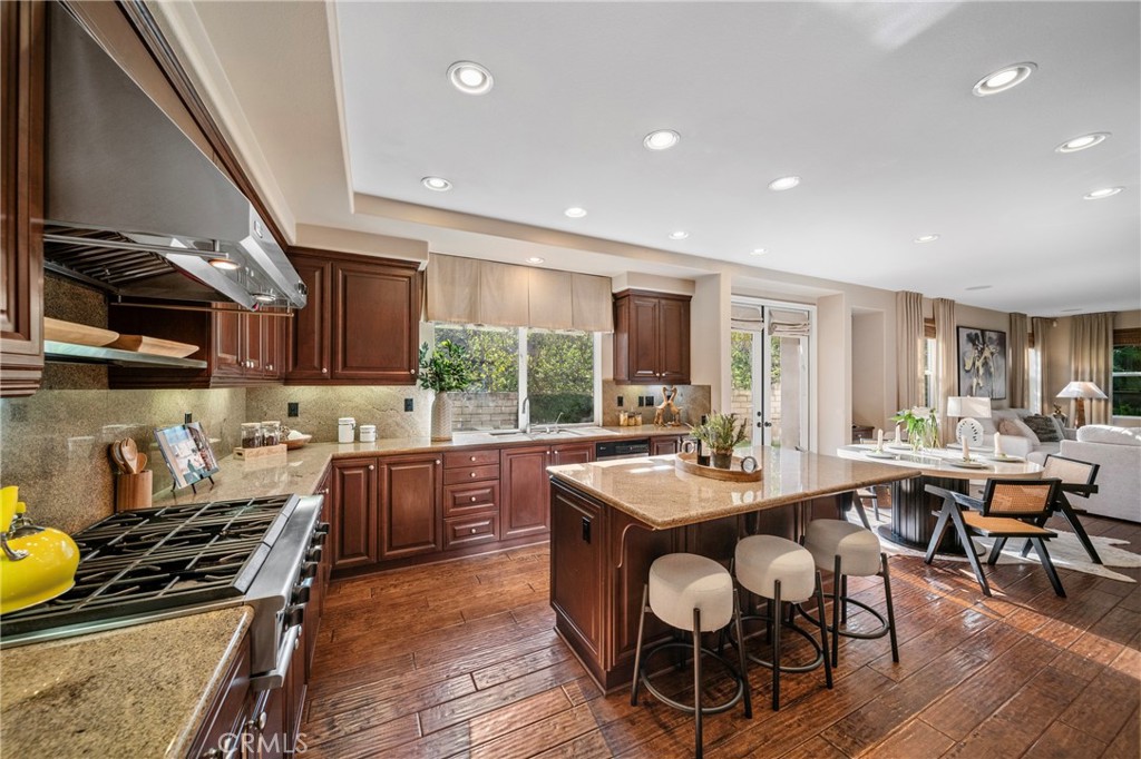 2241 Redwood Drive Glendora, CA 91741 - Photo 20 of 68 a kitchen with a stove a sink a dining table and chairs with wooden floor
