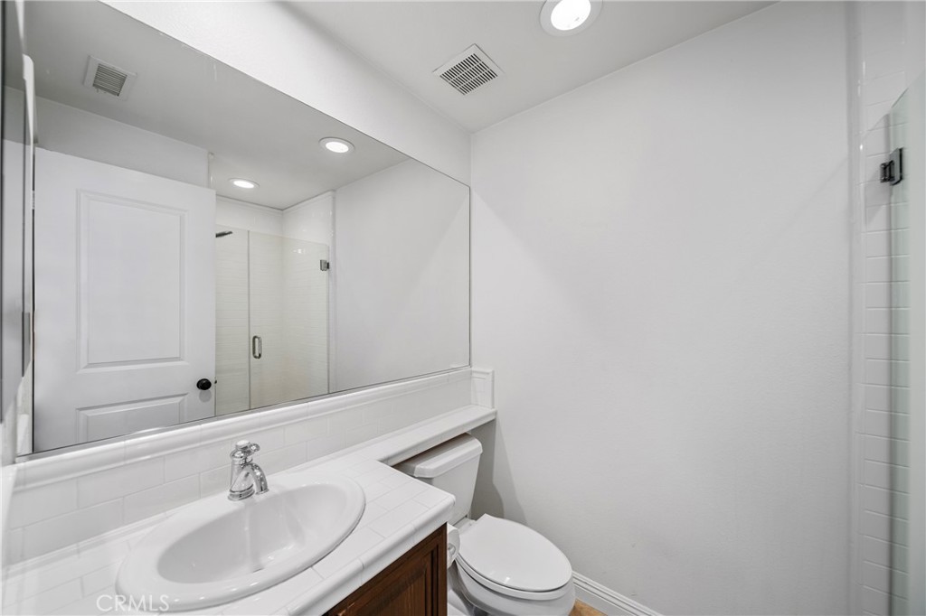 2241 Redwood Drive Glendora, CA 91741 - Photo 39 of 68 a bathroom with a toilet a sink a mirror and vanity