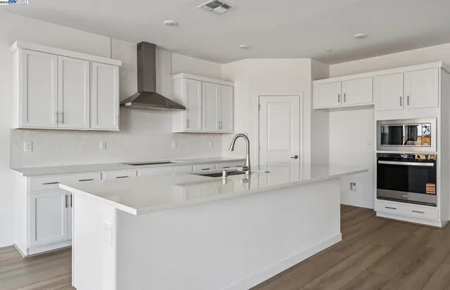 a kitchen with stainless steel appliances granite countertop a sink stove and a refrigerator