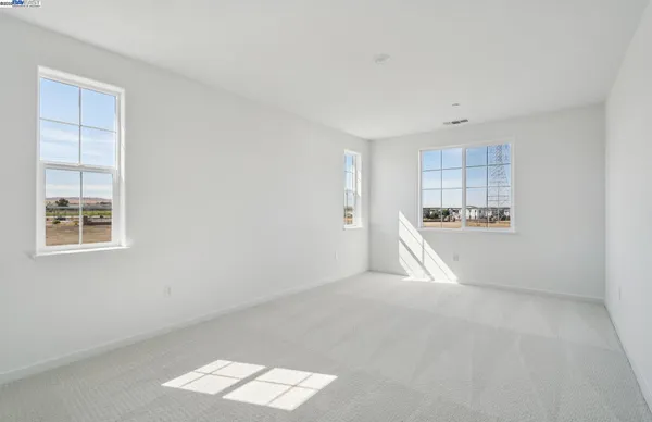 a view of empty room with wooden floor and window