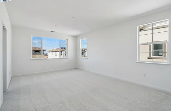 an empty room with windows and cabinet