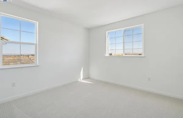 an empty room with windows and closet