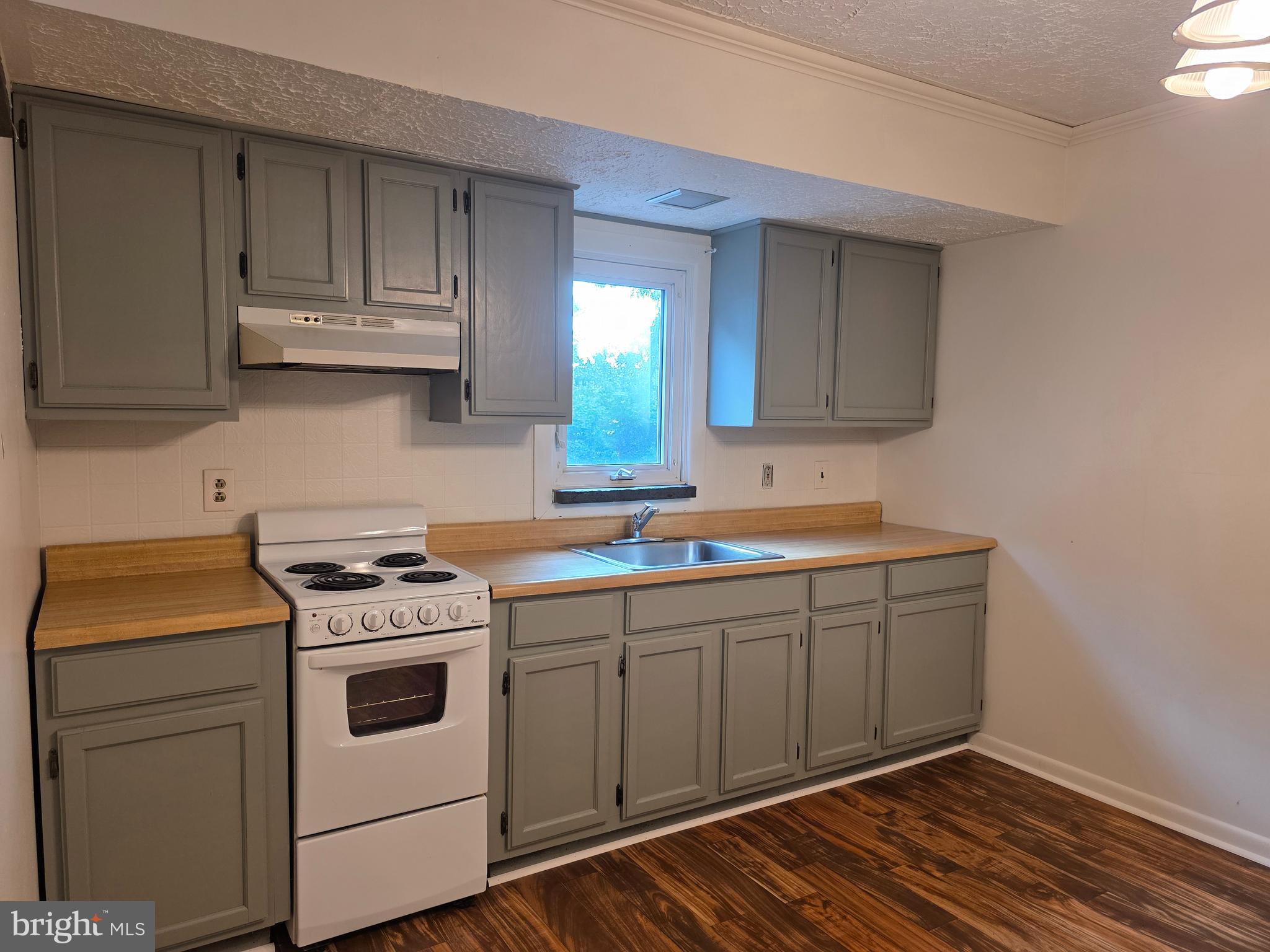 a kitchen with a sink stove and cabinets