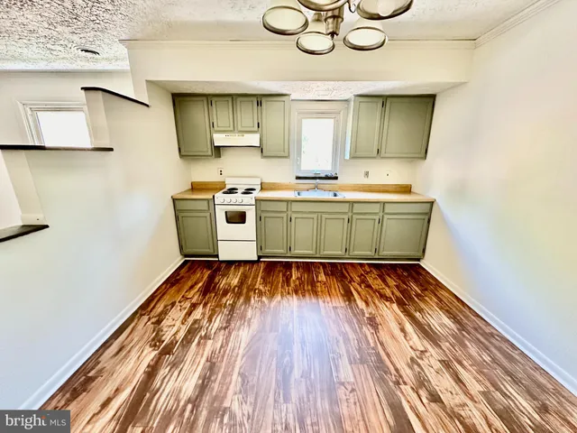 a kitchen with cabinets and wooden floor