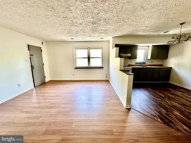 a large kitchen with cabinets wooden floor and stainless steel appliances