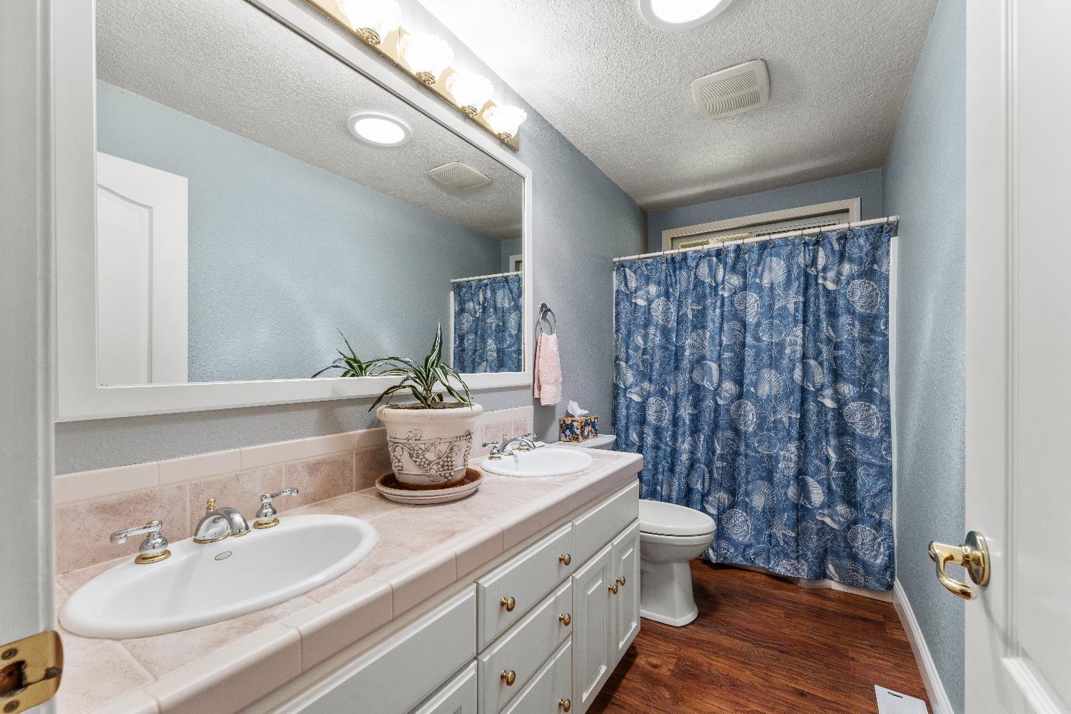 19699 McCourtney Road Grass Valley, CA 95949 - Photo 3 of 27 a bathroom with a double vanity sink toilet and a mirror