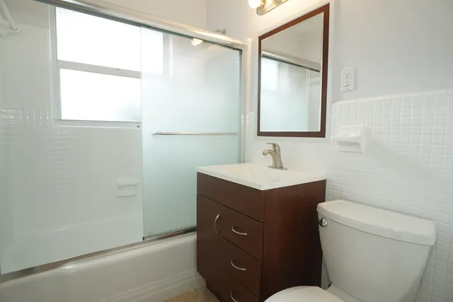 a bathroom with a sink mirror vanity and toilet