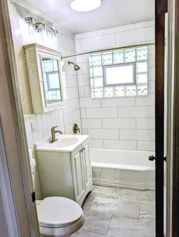 a bathroom with a sink a toilet a tub and shower