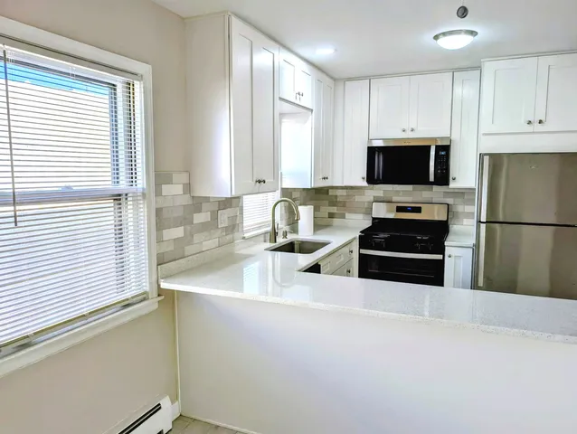a kitchen with stainless steel appliances a refrigerator sink and microwave