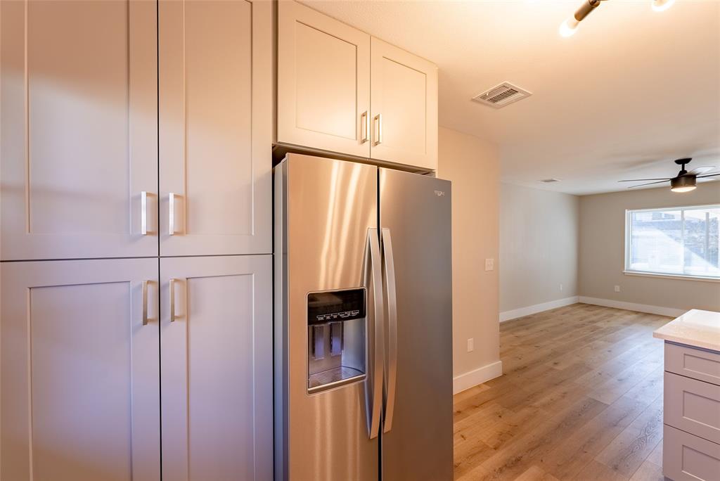 4306 Shallowbrook Trail Austin, TX 78744 - Photo 6 of 16 a view of a kitchen with a refrigerator and wooden floor