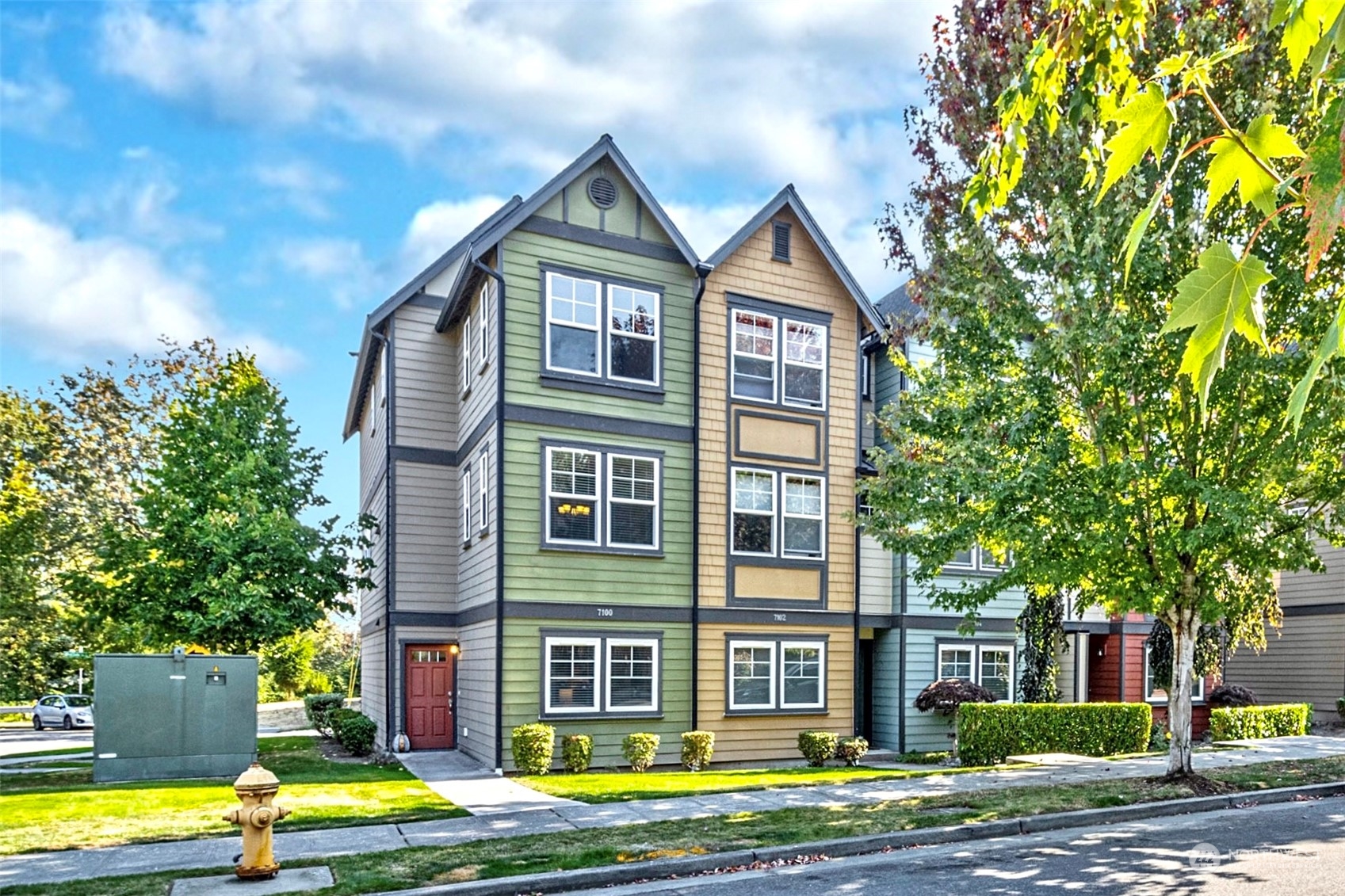 a front view of a house with a yard and trees