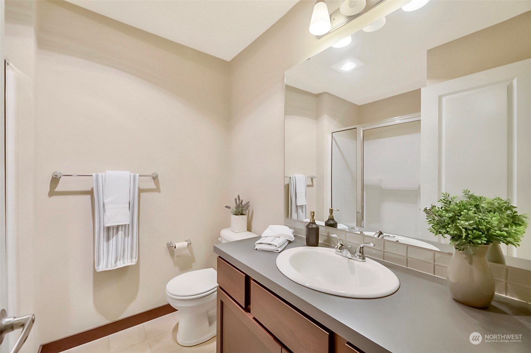 7100 Shinkle Place Southwest Seattle, WA 98106 - Photo 7 of 40 a bathroom with a granite countertop sink a toilet and a mirror