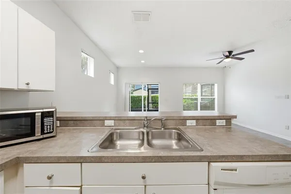 a kitchen with granite countertop a sink a stove and cabinets
