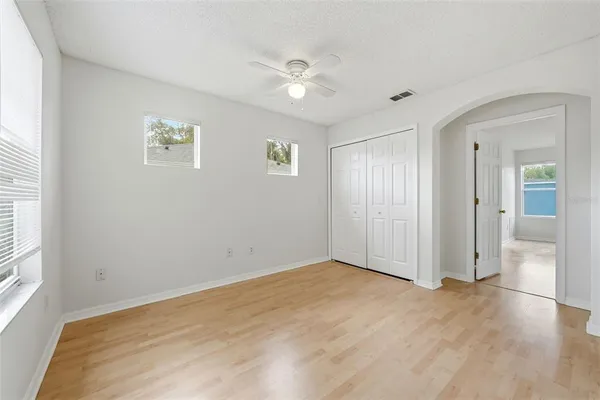 an empty room with wooden floor and windows