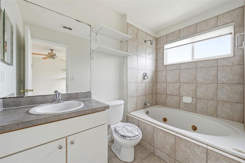 2227 Brancaster Circle Ocoee, FL 34761 - Photo 20 of 30 a bathroom with a granite countertop sink a toilet and bathtub