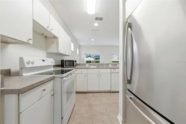 a kitchen with white cabinets and white appliances