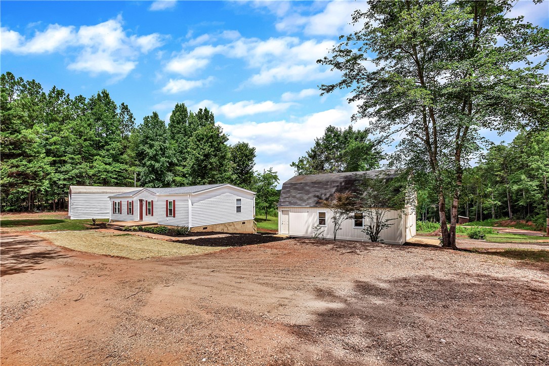403 Hancox Place Westminster, SC 29693 - Photo 3 of 39 Rural retreat with a classic home and versatile outbuilding set amidst a verdant landscape.