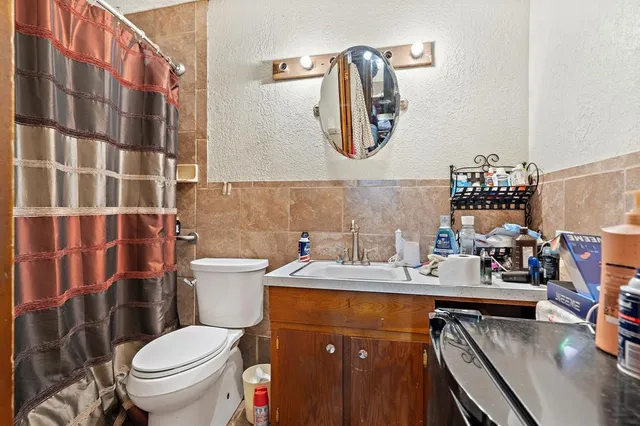 a bathroom with a sink a toilet and a mirror