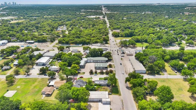 an aerial view of residential houses with outdoor space and trees