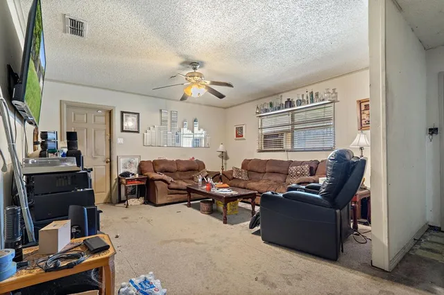 a living room with furniture a flat screen tv and a window