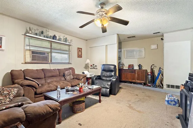 a living room with furniture a ceiling fan and a window