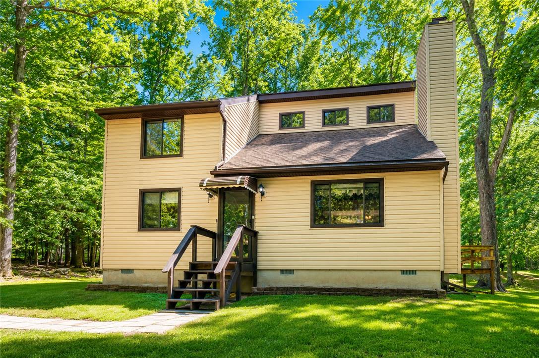 222 Powder Horn Road Henryville, PA 18332 - Photo 1 of 25 Discover a welcoming facade amidst lush, mature trees, offering a private retreat.
