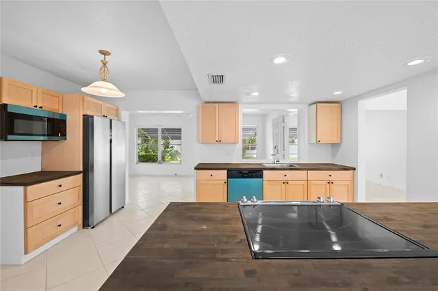 a large kitchen with granite countertop a large counter top space appliances and cabinets