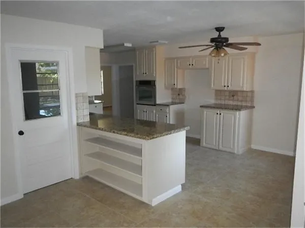 a kitchen with kitchen island a sink stainless steel appliances and cabinets