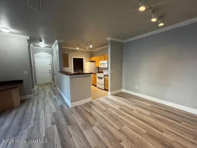 a view of a kitchen with wooden floor and electronic appliances