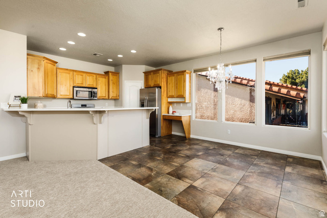 2158 Balboa Way St. George, UT 84770 - Photo 11 of 40 Kitchen featuring recessed lighting, a kitchen bar, a chandelier, light countertops, and appliances with stainless steel finishes