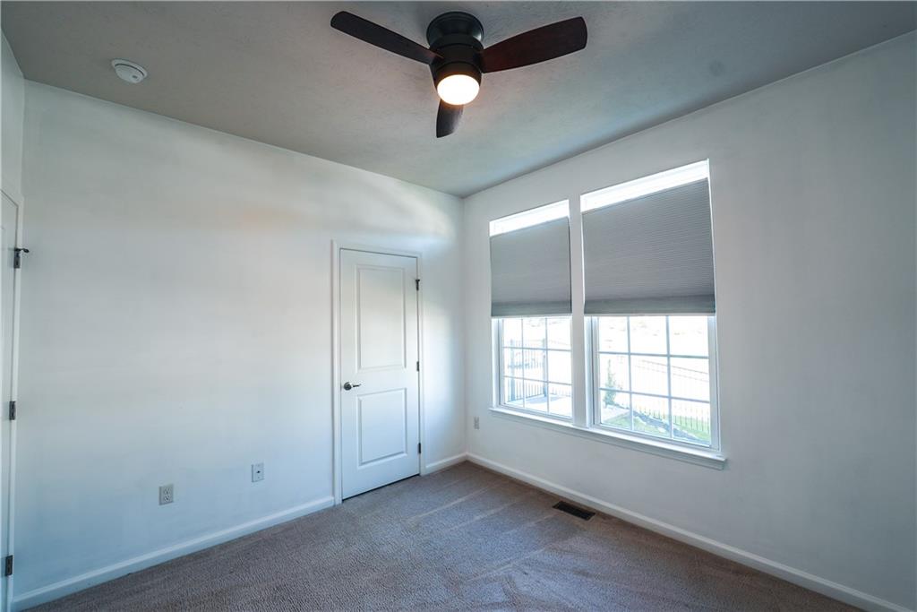 505 October Court Pittsburgh, PA 15239 - Photo 10 of 23 an empty room with ceiling fan and windows