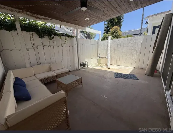 a view of a patio with table and chairs with wooden walls