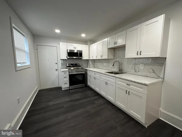 a kitchen with stainless steel appliances granite countertop a stove sink and cabinets