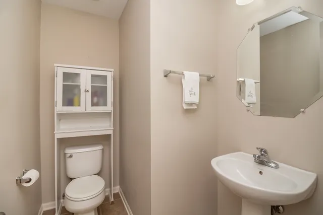 a bathroom with a sink a toilet and a mirror