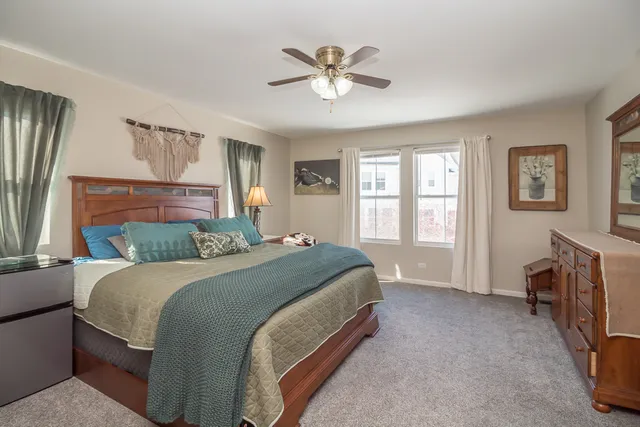 a bed room with a bed and a ceiling fan