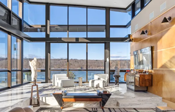 a living room with furniture kitchen view and a large window