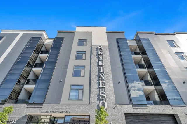 a view of a hallway with wooden floor and a chandelier