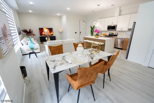 a view of a dining room with furniture and a kitchen